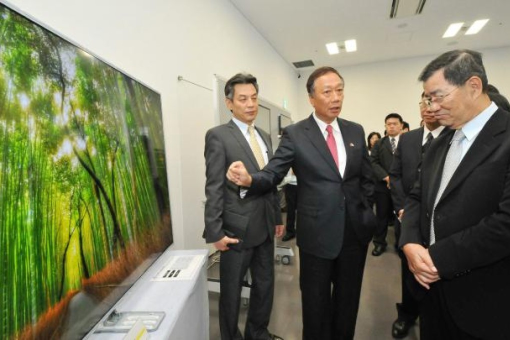 Hon Hai chairman Terry Gou (centre) visits a Sharp plant in Sakai, Japan. Photo: AFP