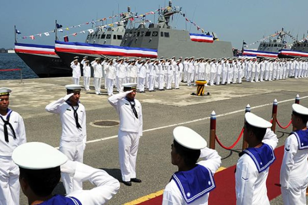Navy soldiers salute in front of homemade missile boats during the inauguration ceremony at the Tsuoying naval base in southern Taiwan. Photo: AFP