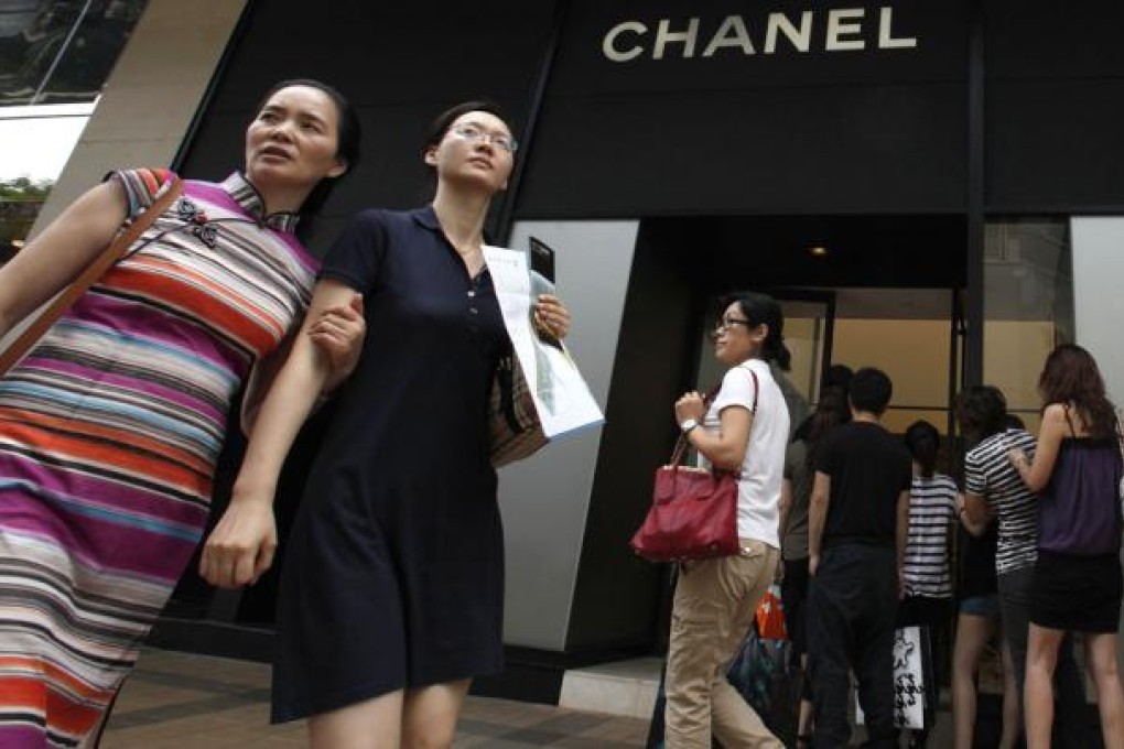 Mainland Chinese visitors walk past a Chanel store as others line up outside at Hong Kong's tourist Tsim Sha Tsui district. Photo: Reuters