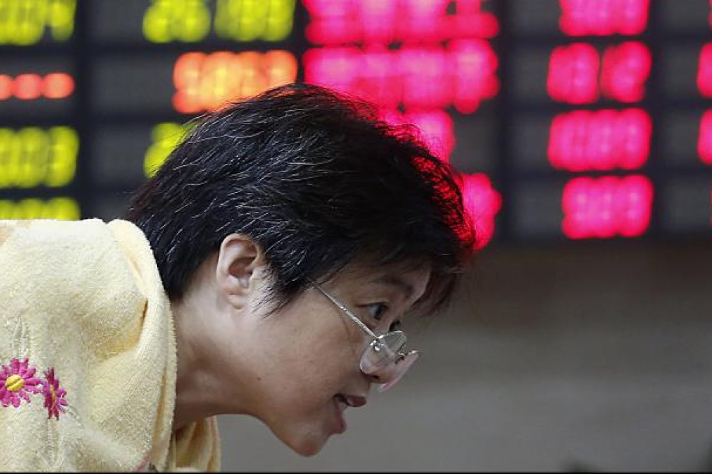 An investor looks at stock prices in Shanghai. Fears of a hard landing in China are casting a pall over stock markets elsewhere in the region, particularly Hong Kong.  Photo: AP