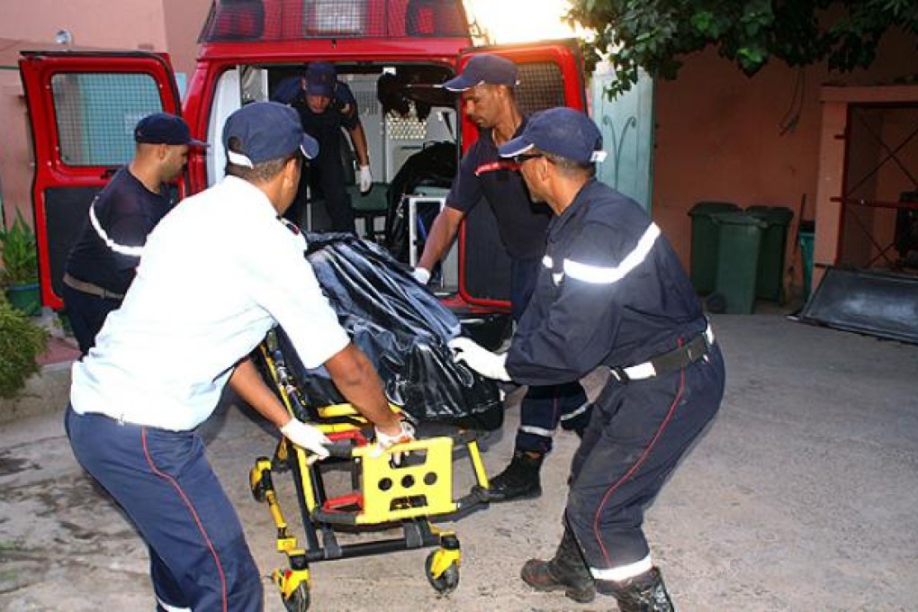Moroccan rescuers carry the body of a passenger who was killed in a bus crash to a hospital morgue in Marrakech on Tuesday. Photo: AFP