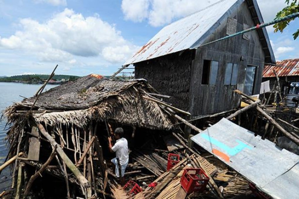 A resident fixes his damaged home after an earthquake hit the town of General MacArthur, eastern Samar province, in the central Philippines. Photo: AP