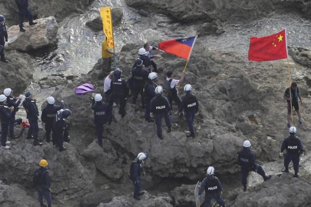 Activists with Chinese and Taiwanese flags are arrested by Japanese police after landing on a disputed island on August 15. Photo: AP