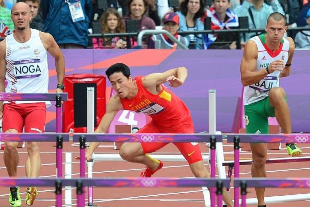 China's Liu Xiang (C) falls while competing in the men's 110m hurdles heats at the Olympic Games in London. Photo: AFP