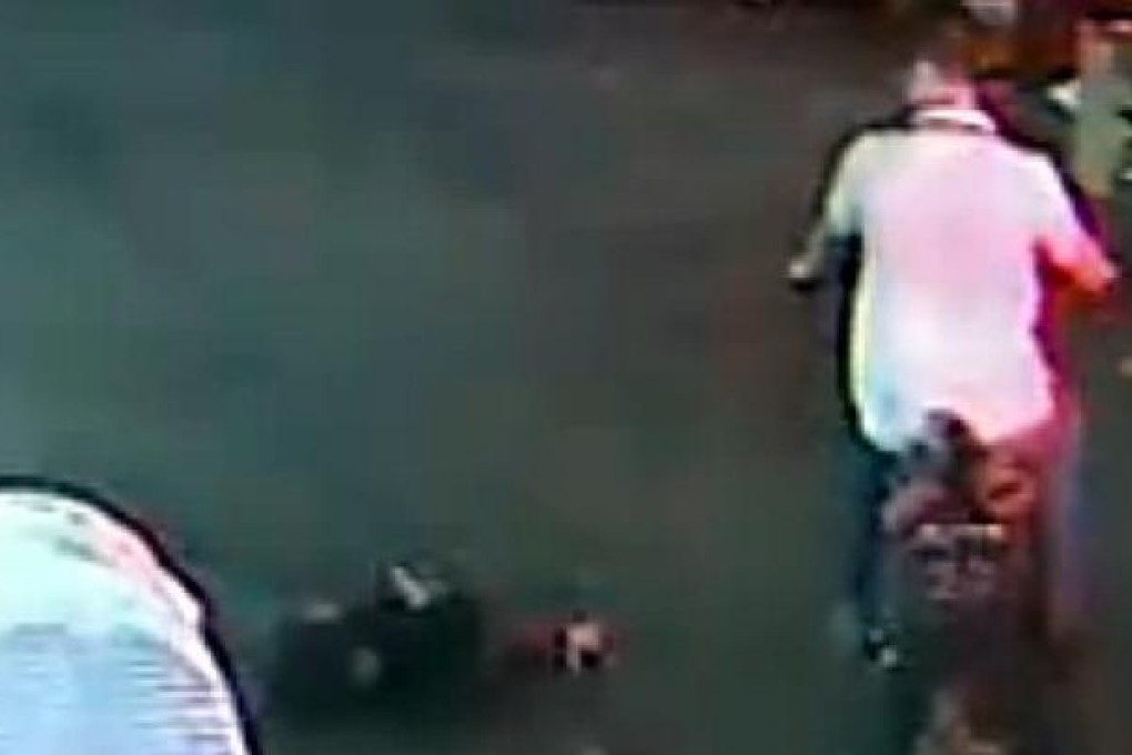 In a screen grab of the hit-and-run video, a person passes by toddler Yue Yue lying on the road. Photo: SCMP Pictures