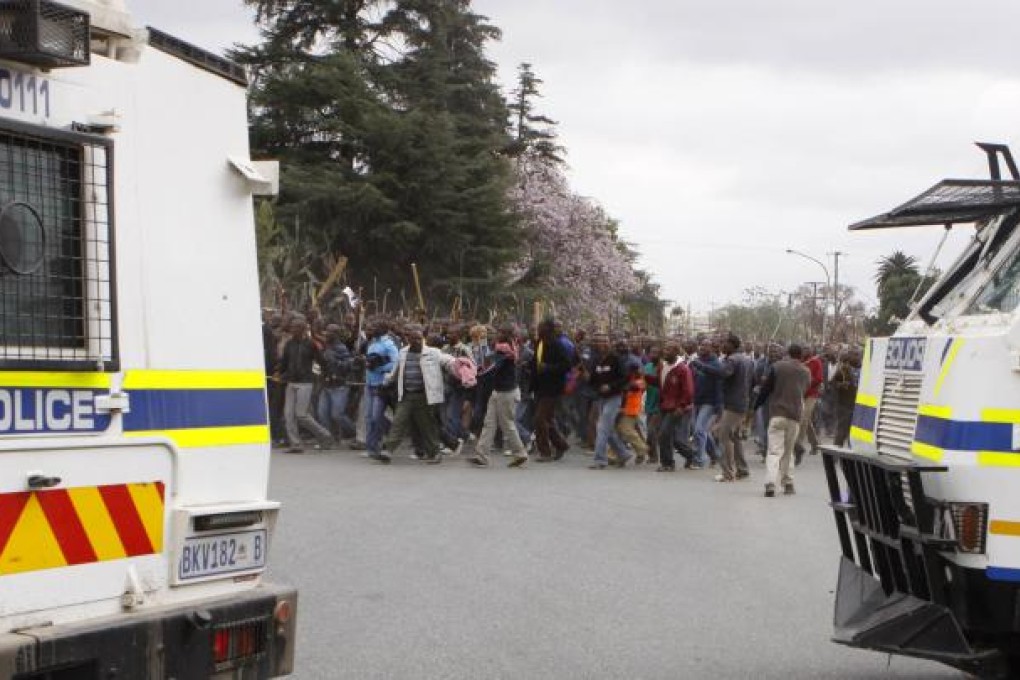 Police try to prevent striking mine workers from marching to the Karee shaft at the Lonmin Platinum Mine near Rustenburg on Wednesday. Photo: AP