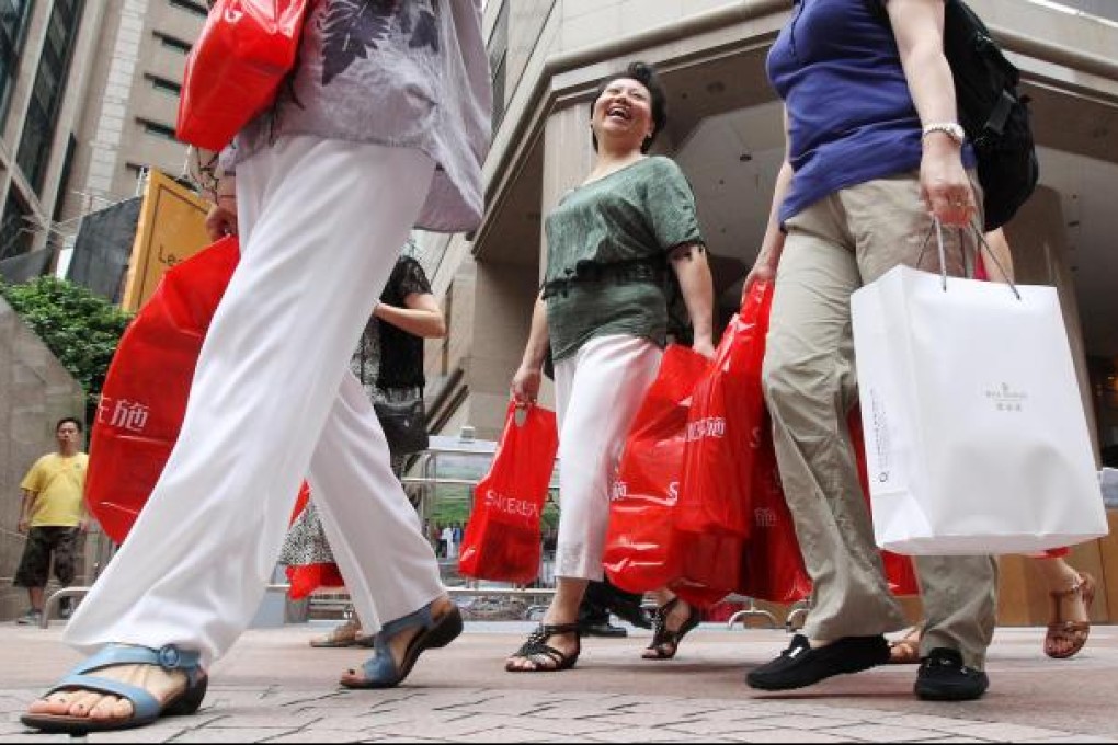 Mainland tourists carry bags full of goods during a buying spree in Causeway Bay, a popular shopping area for visitors. Photo: KY Cheng