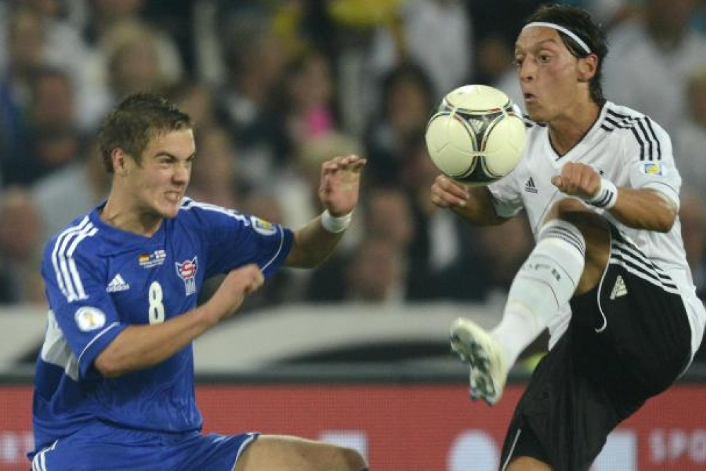 Germany's Mesut Ozil (right) challenges Hallur Hansson of Faroe Islands during their World Cup qualifying match. Photo: Reuters