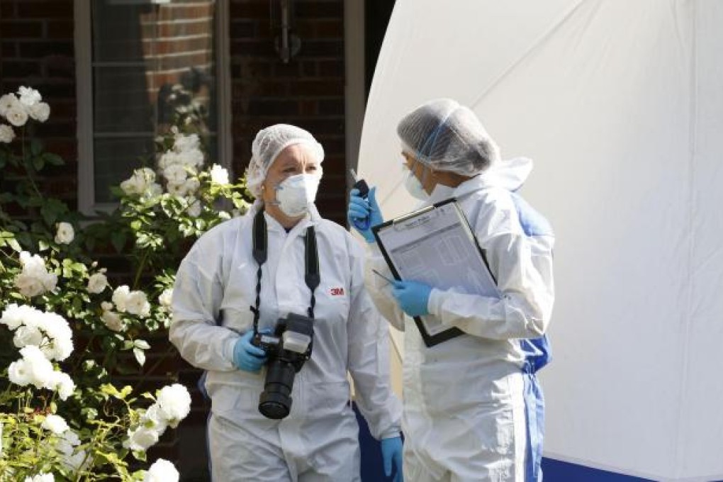 Police forensic officers conduct investigations outside the murdered family's home in Claygate, southern England. Photo: AFP