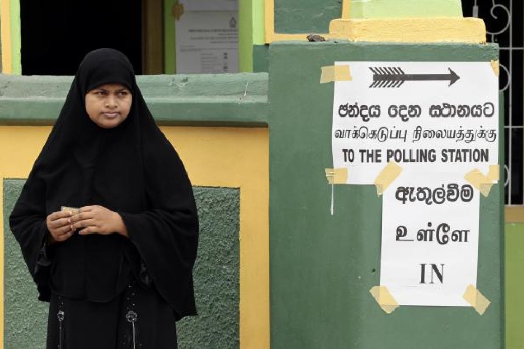 A Sri Lankan woman outside a polling station. Photo: AP