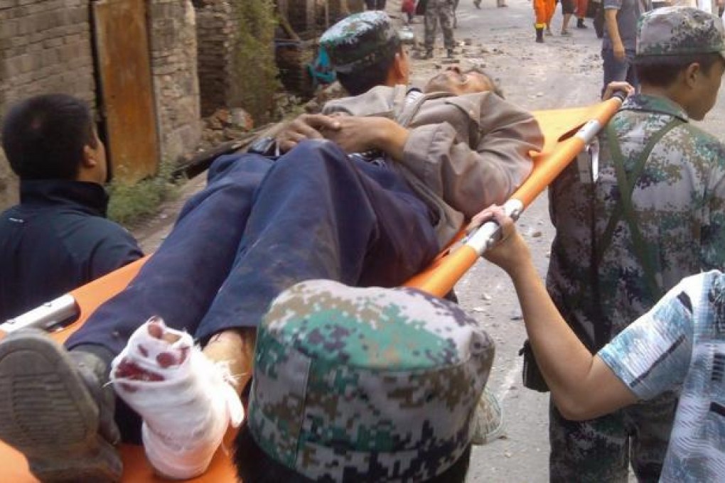 Rescue workers help an injured villager. Photo: Xinhua