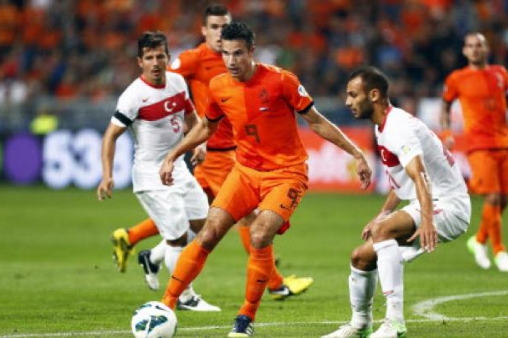Dutch player Robin van Persie (centre) in action against Omer Toprak (right) from Turkey during their FIFA World Cup 2014 qualifying soccer match in Amsterdam, Netherlands. Photo: EPA