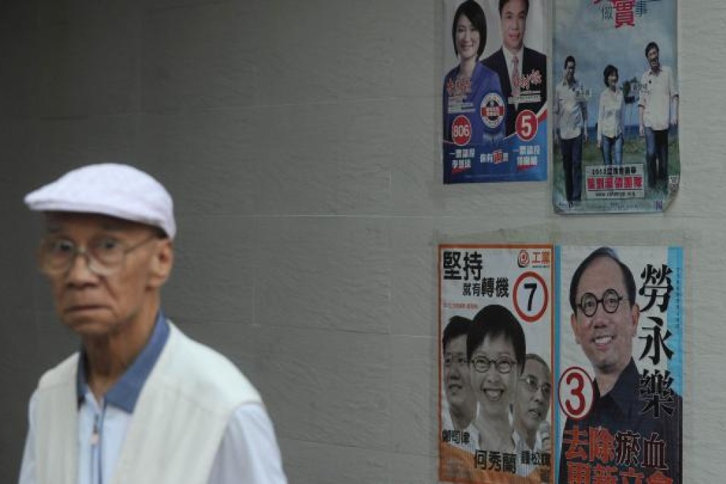 A man walks past campaign posters ahead of legislative council elections in Hong Kong on September 9, 2012. Photo: AFP/Dale de la Rey