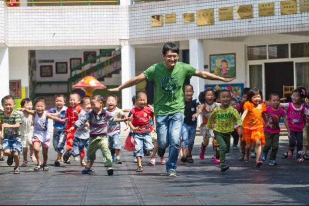 A kindergarten teacher, Wang Yu, plays with children in Tongxiang, Zhejiang. The job is about to become a lot less fun for some. Photo: Xinhua