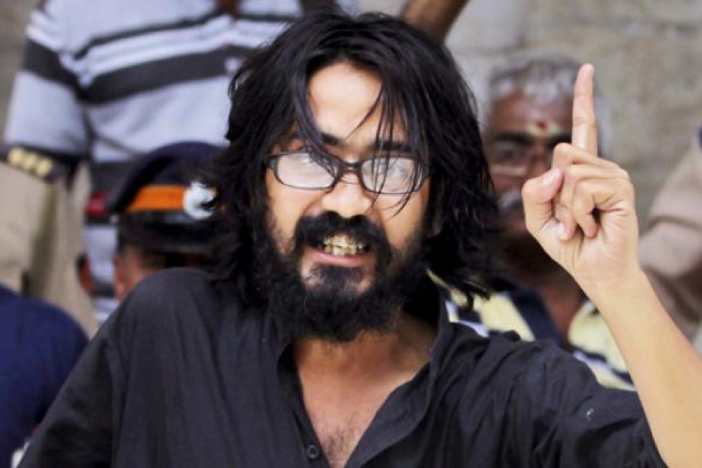 Indian political cartoonist Aseem Trivedi gestures after he is arrested on charges of mocking the Indian constitution in his drawings on Sunday. Photo: AP