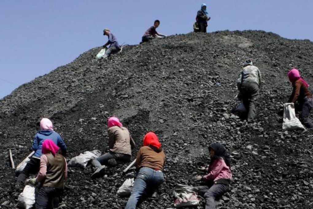 Villagers scavenge low-grade coal from the tailings at a massive coal mine near You Fang Liang, in Ningxia Hui Autonomous Region. Photo: EPA