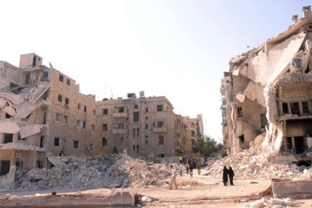 People walk past a row of destroyed buildings near the Al-Hayat Hospital in the northern Syrian city of Aleppo on Monday. Photo: AFP