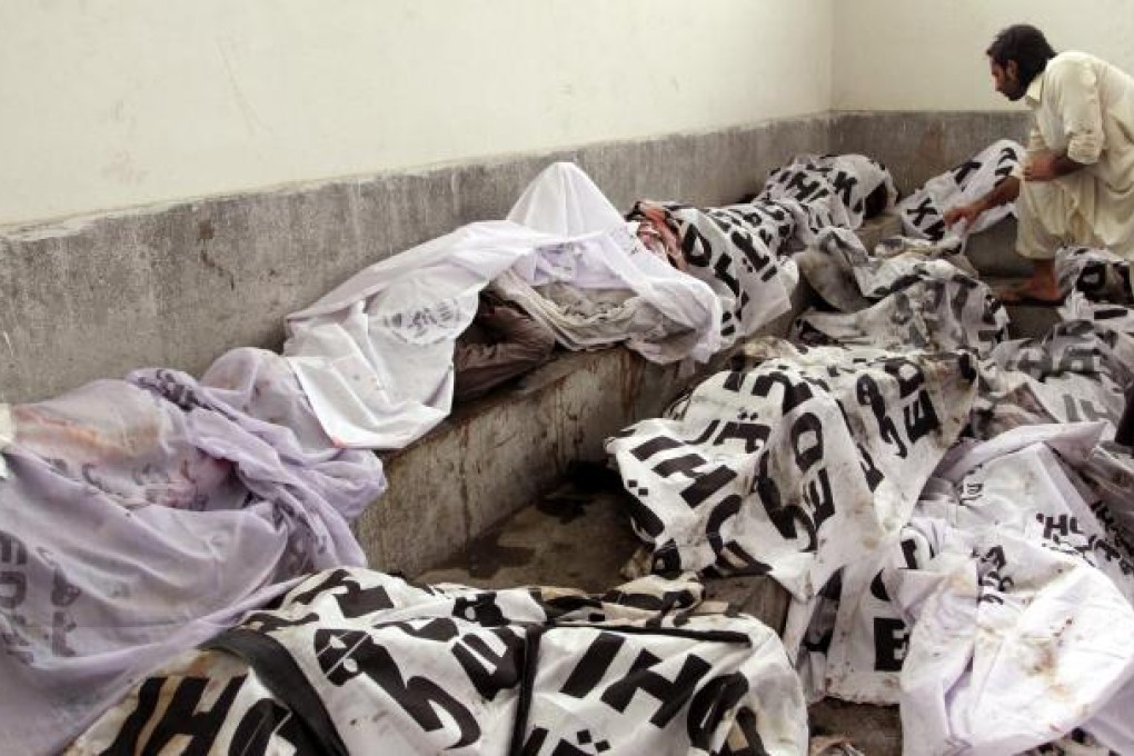 A man tries to identify the body of his relative at a Karachi morgue in the fire's aftermath. Photo: EPA