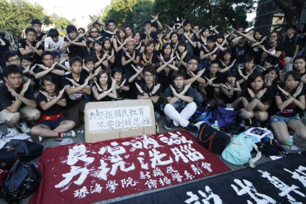 Thousands of university students gesture near a banner reading "Calling from conscience, to resist brainwashing," as they stage a class boycott on the subject "Moral and National Education" during a demonstration at the Chinese University in Hong Kong. Photo: AP