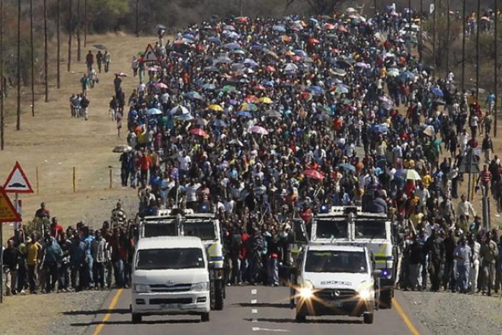 Some of the thousands of striking miners from the Lonmin platinum mine march to the gates of Lonmin mines as part of their mass action in an attempt to get higher wages on Monday. Photo: EPA