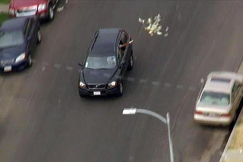 Locals swarmed into the road causing chaos after the robbers gave away their cash. Photo: AP