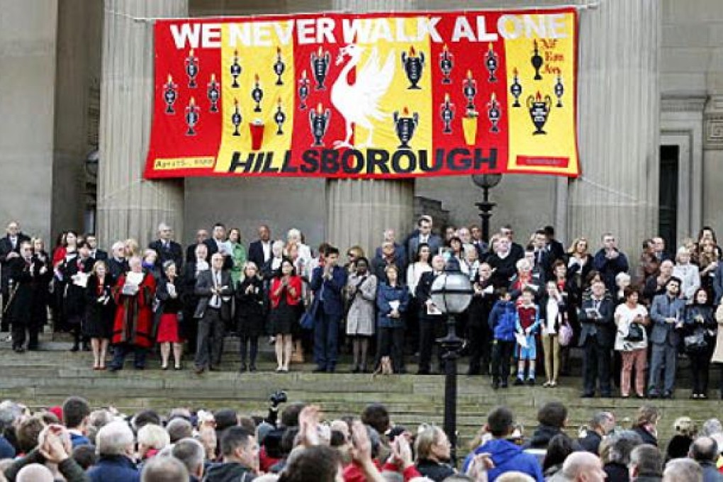 People gather at St George's Place to attend a vigil in memory of the 96 victims of the Hillsborough stadium disaster in Liverpool, England on Wednesday.