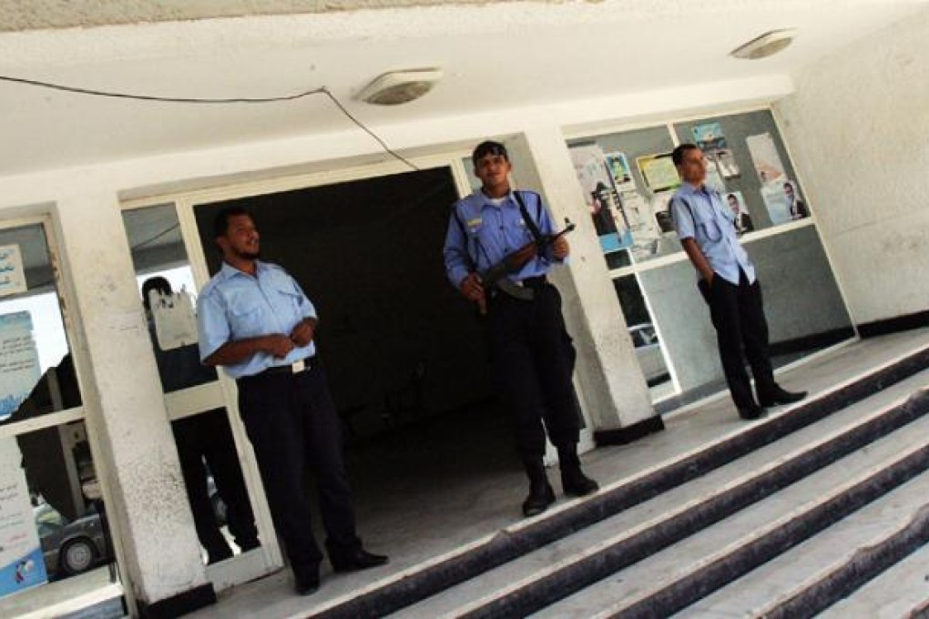 Libyan security men stand at the entrance of a police station on Thursday in Benghazi. Photo: AFP