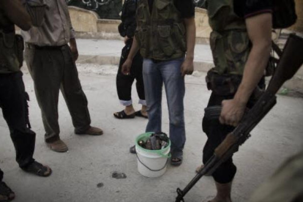 Syrian rebels gather around a bucket of mortars while fighting with scarce ammunition in the Saif al-Dawla neighbourhood of Aleppo on Wednesday. Photo: AFP