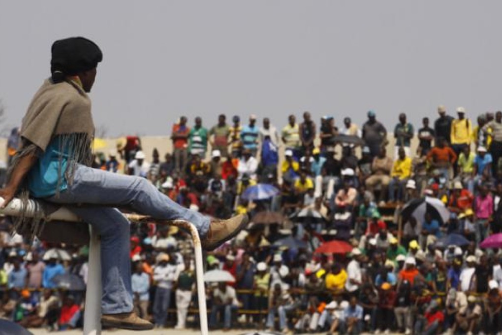 Striking workers at the Blesbok Stadium of the Anglo Platinum mine near Rustenburg, South Africa, wait for a report back on Thursday before deciding on what action to take against mine management. Photo: AP