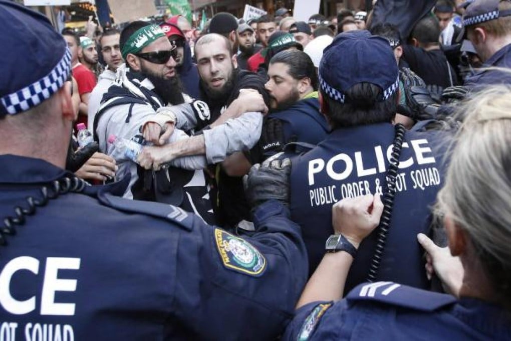 Muslim protesters rallying against a US film mocking their religion clash with Australian police in Sydney yesterday. Photo: Reuters