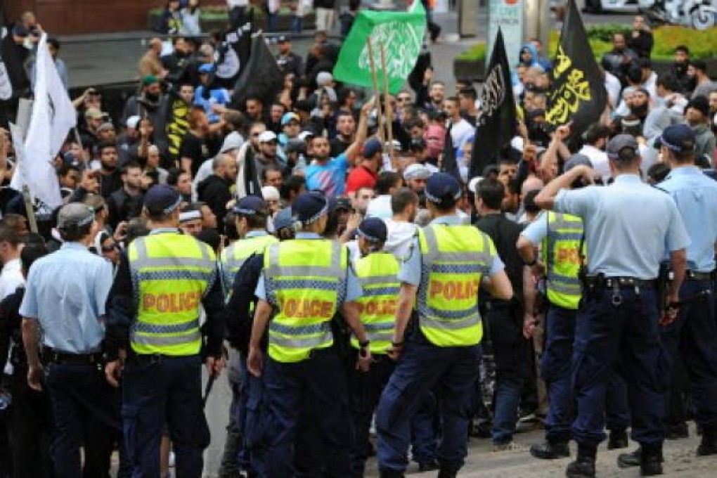 Police watch protesters near the US Consulate General in central Sydney on Saturday, as a wave of unrest against a film that mocks Islam spread to Australia, bringing hundreds out to demonstrate. Photo: AFP