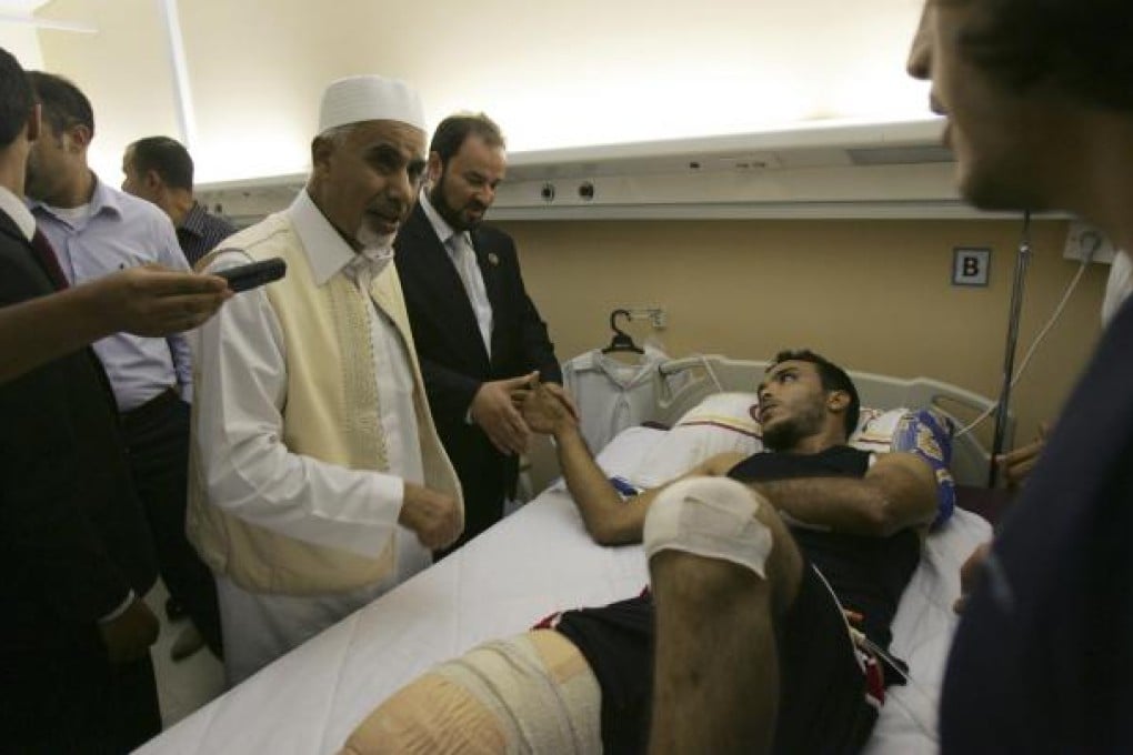 President Mohammed el-Megarif visits wounded guards. Photo: AP