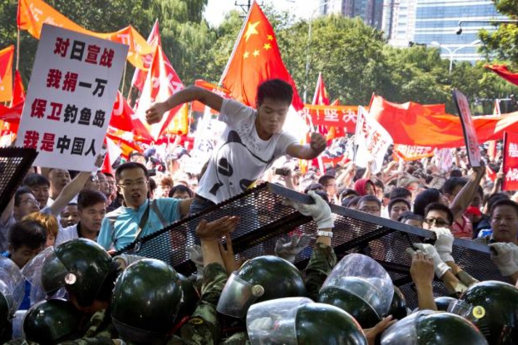 One placard slogan urges "declare war on Japan" as demonstrators in Beijing kick a barricade. Photo: AP