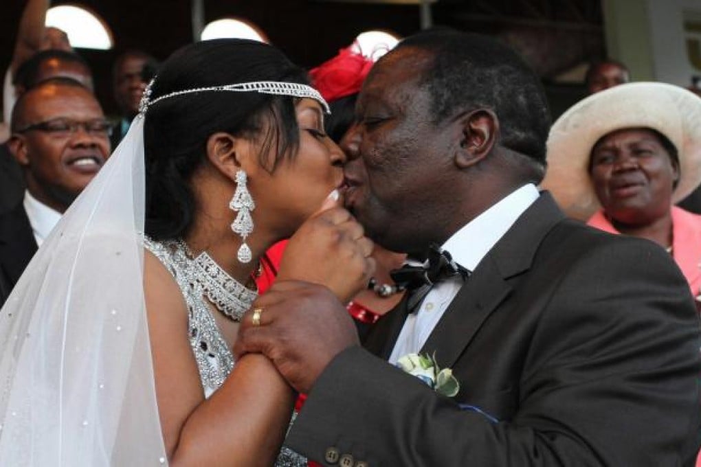 Zimbabwean Prime Minister Morgan Tsvangirai kisses his new wife, Elizabeth Macheka, during their controversial wedding. Photo: EPA