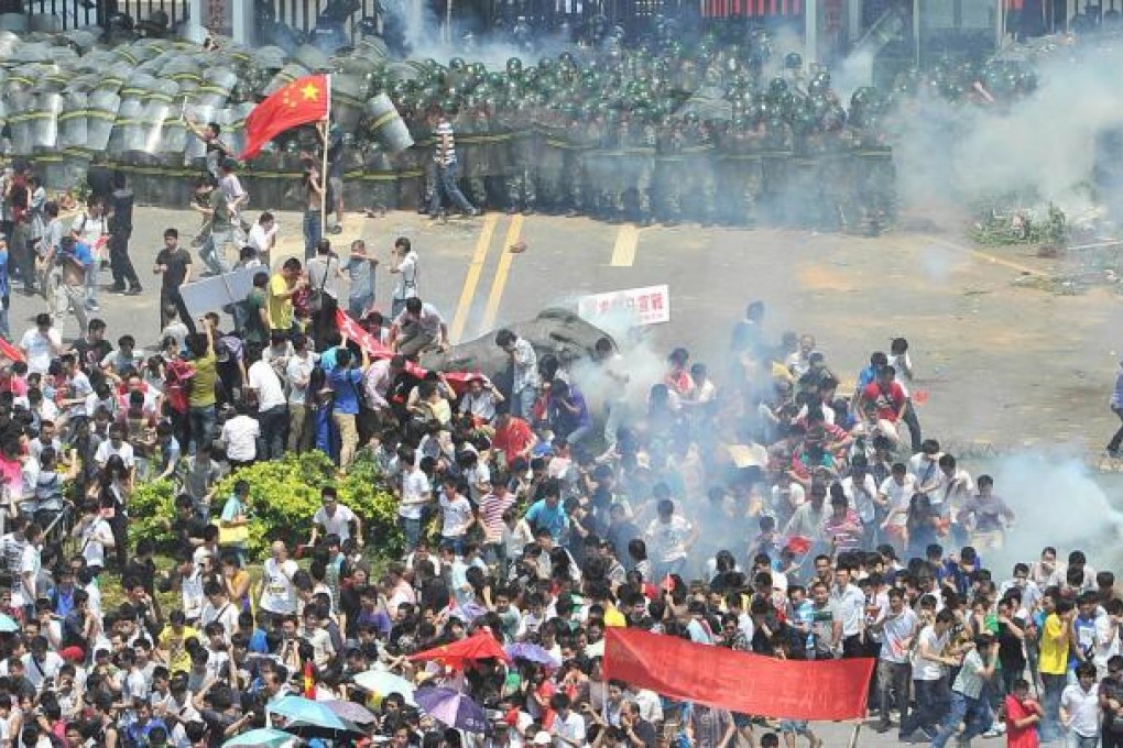 Demonstrators disperse after tear gas is fired into the crowd in Shenzhen yesterday. Photo: AFP
