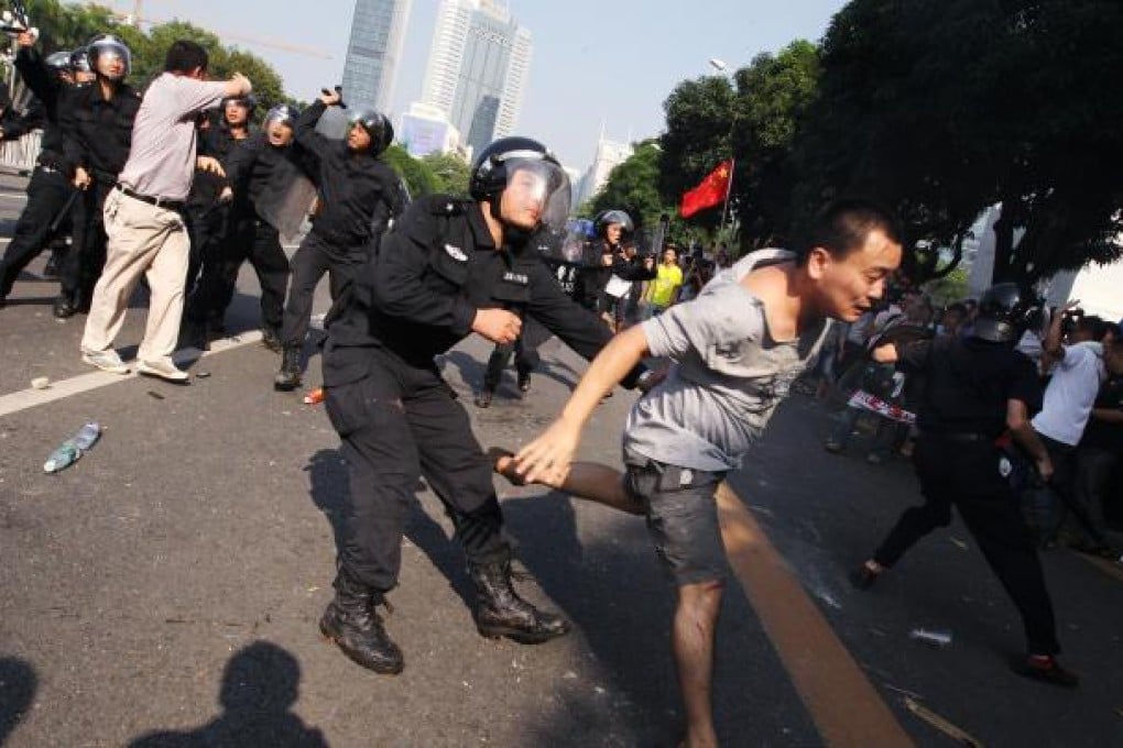 Riot police wielding batons confront anti-Japanese protesters amid angry scenes on the streets of Shenzhen yesterday. Photo: Felix Wong