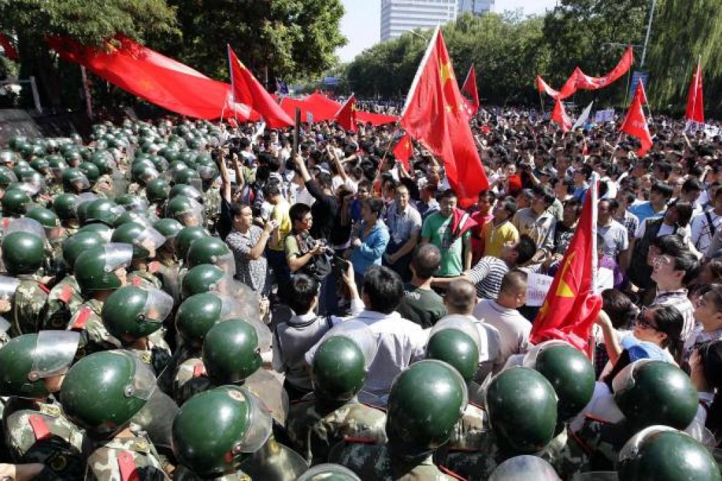 Riot police form a human barrier to block demonstrators outside the Japanese embassy in Beijing. Photo: Reuters