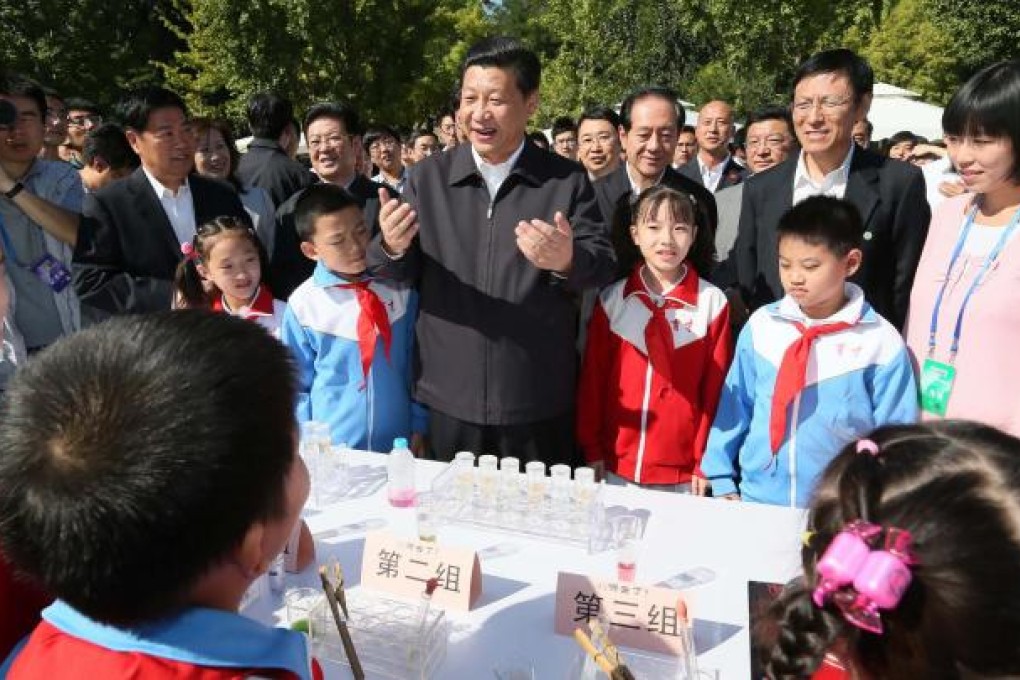 Smiling Xi Jinping chats with children on his first public appearance for two weeks at China Agricultural University. Photo: Xinhua