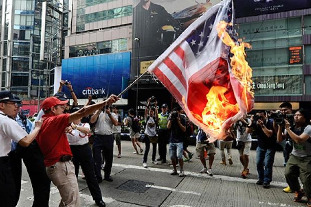 A Hong Kong protester lighted and waved a flag that melded the Japanese and American emblems. He was arrested for disorder in a public place soon after. Photo: AFP