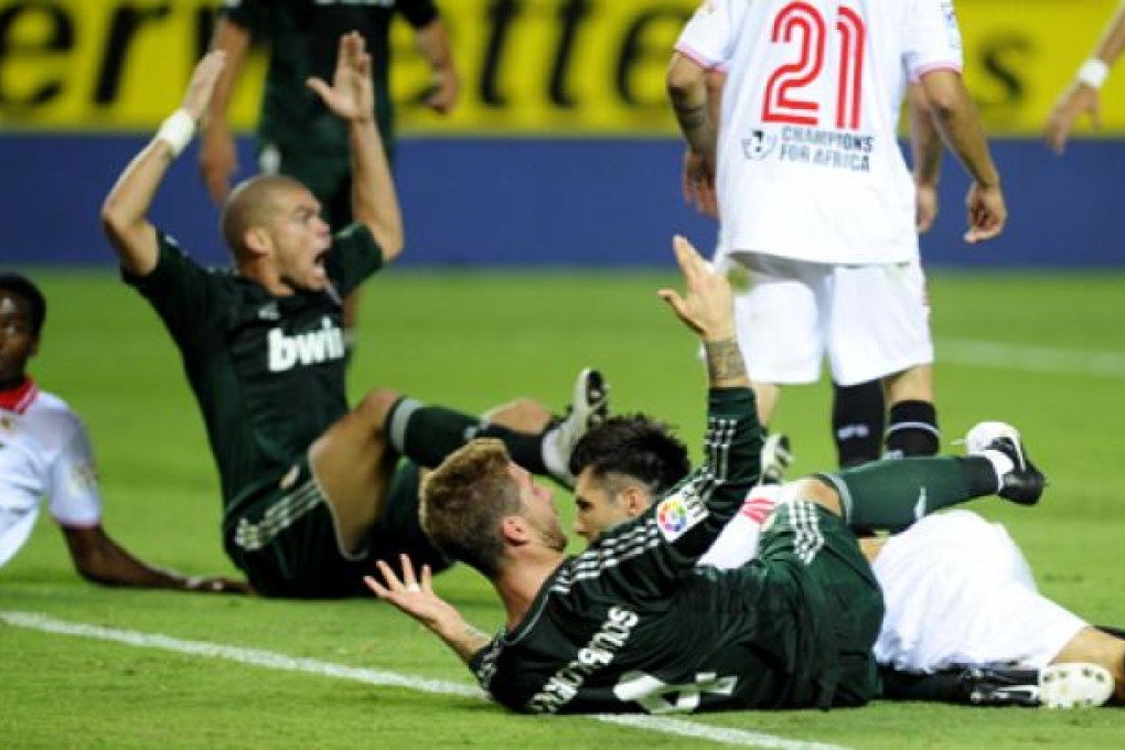 Real Madrid's Sergio Ramos (centre) and teammate Karim Benzema protest a call in a match against Sevilla FC on Saturday. Photo: AFP