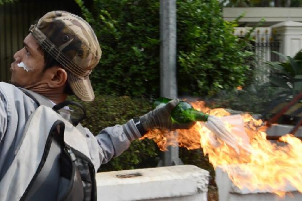 An Indonesian protester hurls a molotov coctail towards the US embassy during a protest on Monday. Photo: AFP
