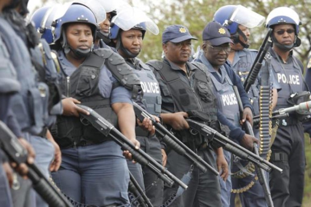 South African police block a main road to prevent un-armed miners from the Anglo Platinum Mine from reaching the police station in Rustenburg on Sunday. Photo: EPA