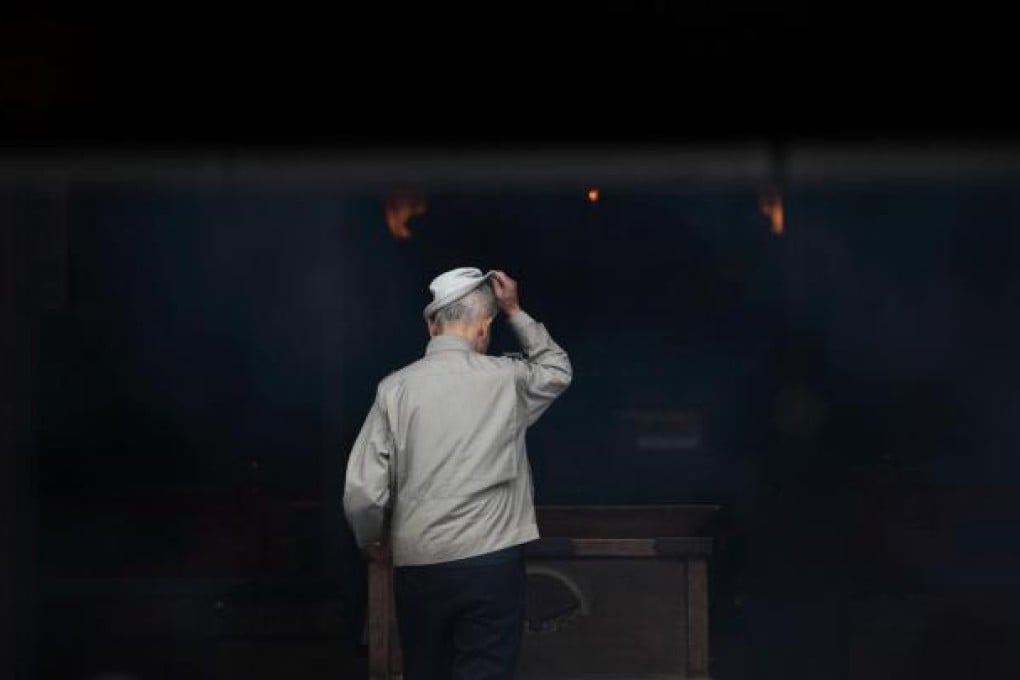 An elderly man visits a shrine in the Sugamo district of Tokyo. Japan ages faster than any other developed society, with 23 per cent of its population 65 or older. One such individual is Hirofumi Mishima, below right, who like many of his ilk, is still in the workforce for money, health or seeking new friends. Photos: Bloomberg