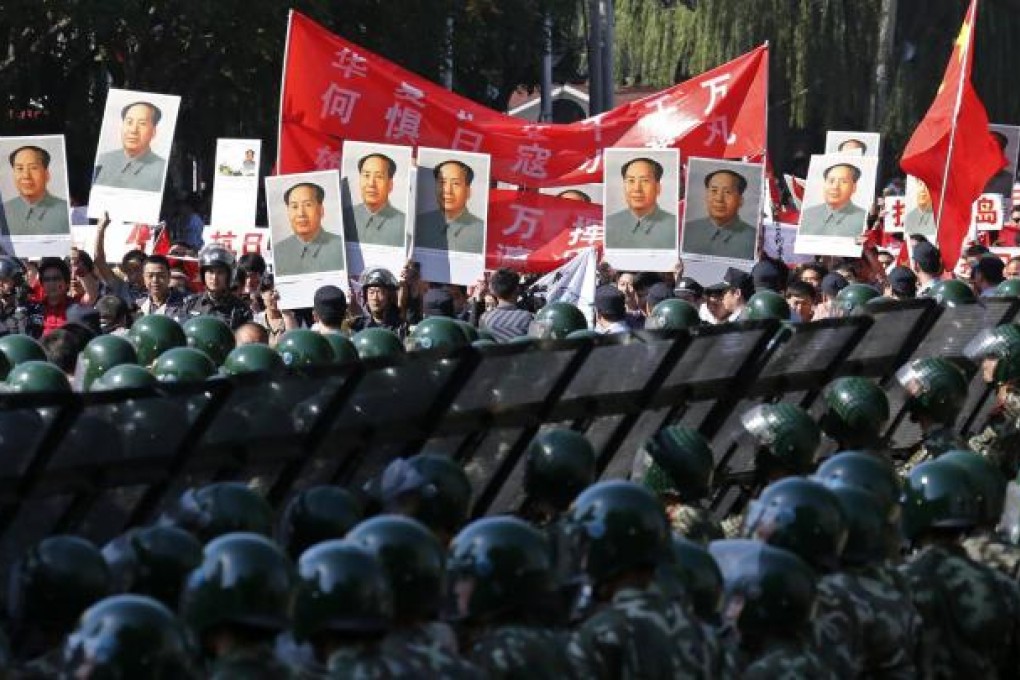 Rows of soldiers stand guard as protesters with portraits of Mao Zedong gather at the Japanese embassy in Beijing. Photo: Reuters
