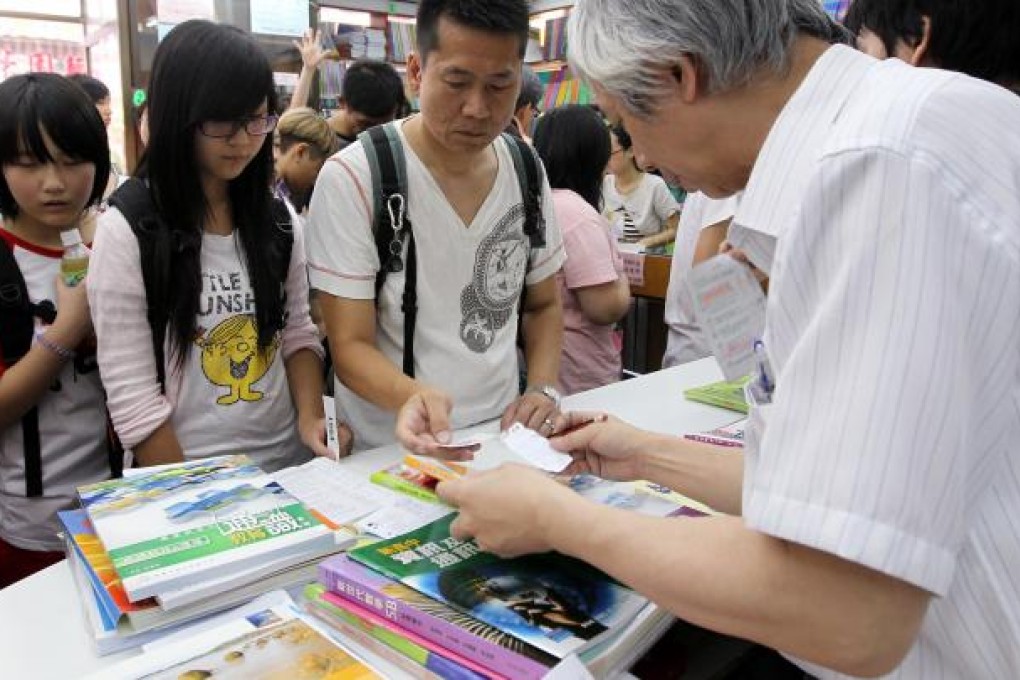 Students and parents check the cost of buying secondary school textbooks at a shop in Mong Kok. Secondary school book prices have gone up on average by 2.5 per cent.Photo: Dickson Lee