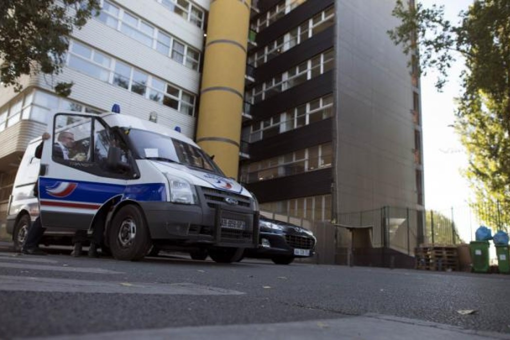 Policemen stand in front of the building which houses the headquarters of French satirical weekly <i>Charlie Hebdo</i> on Wednesday in Paris. Photo: AFP