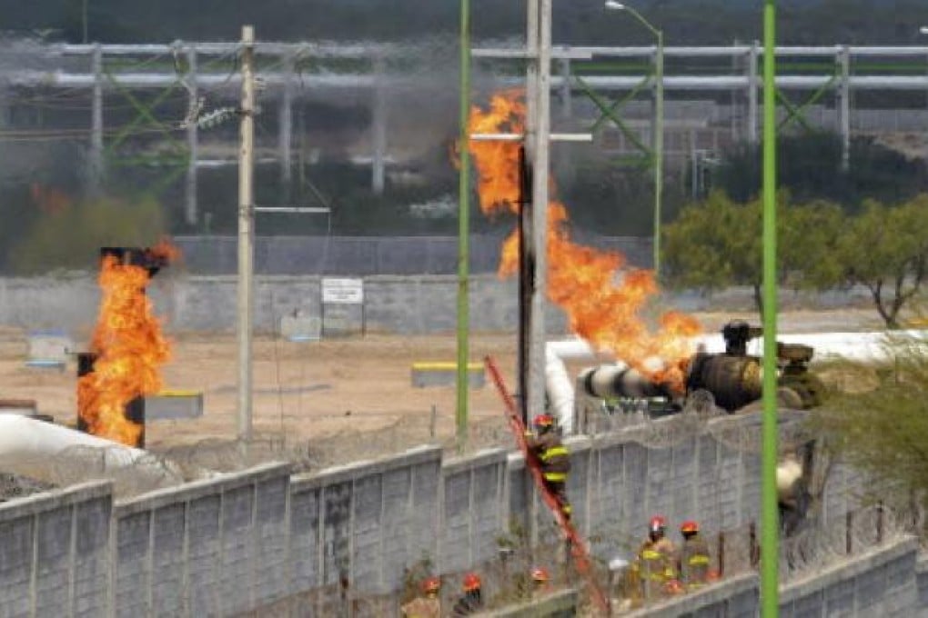 Firefighters try to control a fire after an explosion at a gas pipeline distribution center in Reynosa, near Mexico's border with the US on Tuesday. The fire has killed at least  26 people.