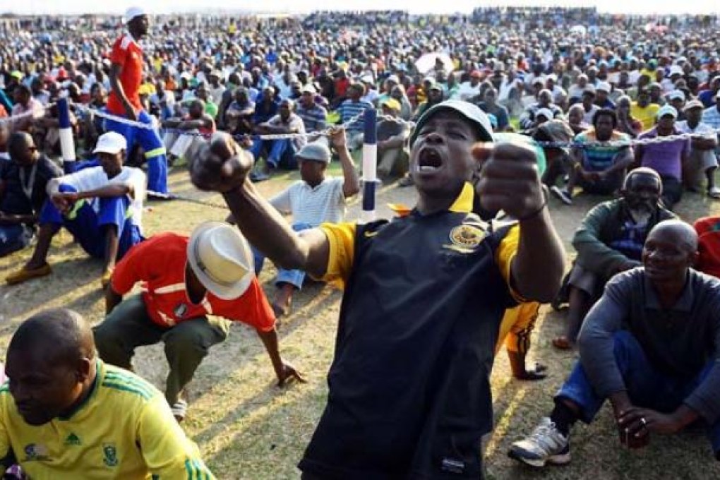 A miner from the Lonmin platinum mine celebrates after the striking workers and mine management came to an agreement on a wage increase six weeks after their illegal strike started in Marikana, South Africa, on Wednesday. Photo: EPA