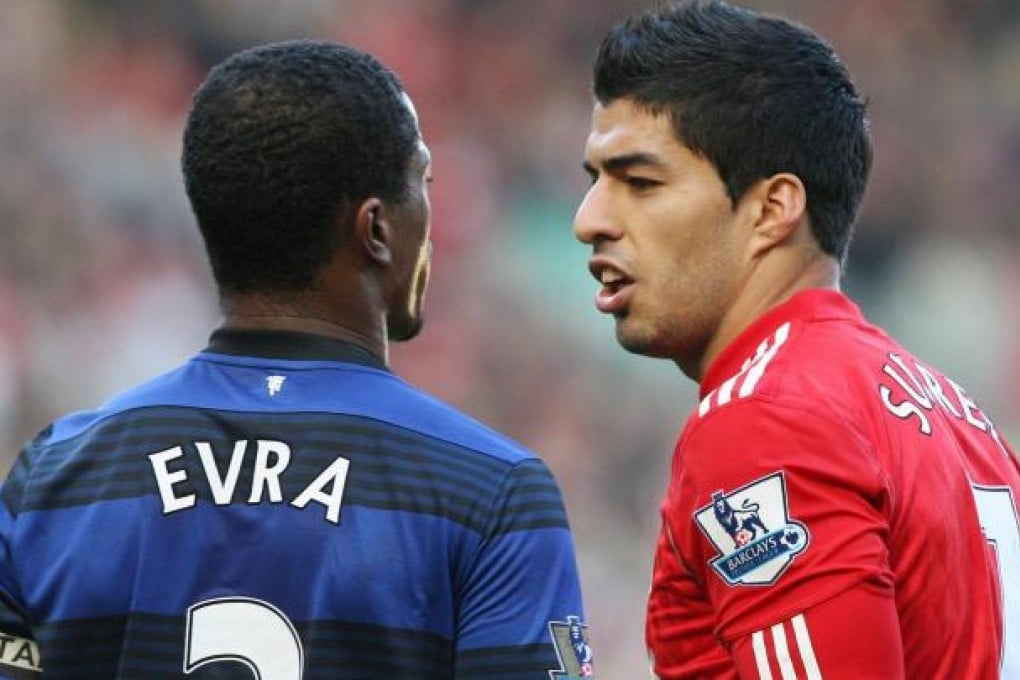 Suarez (right) and Evra clash