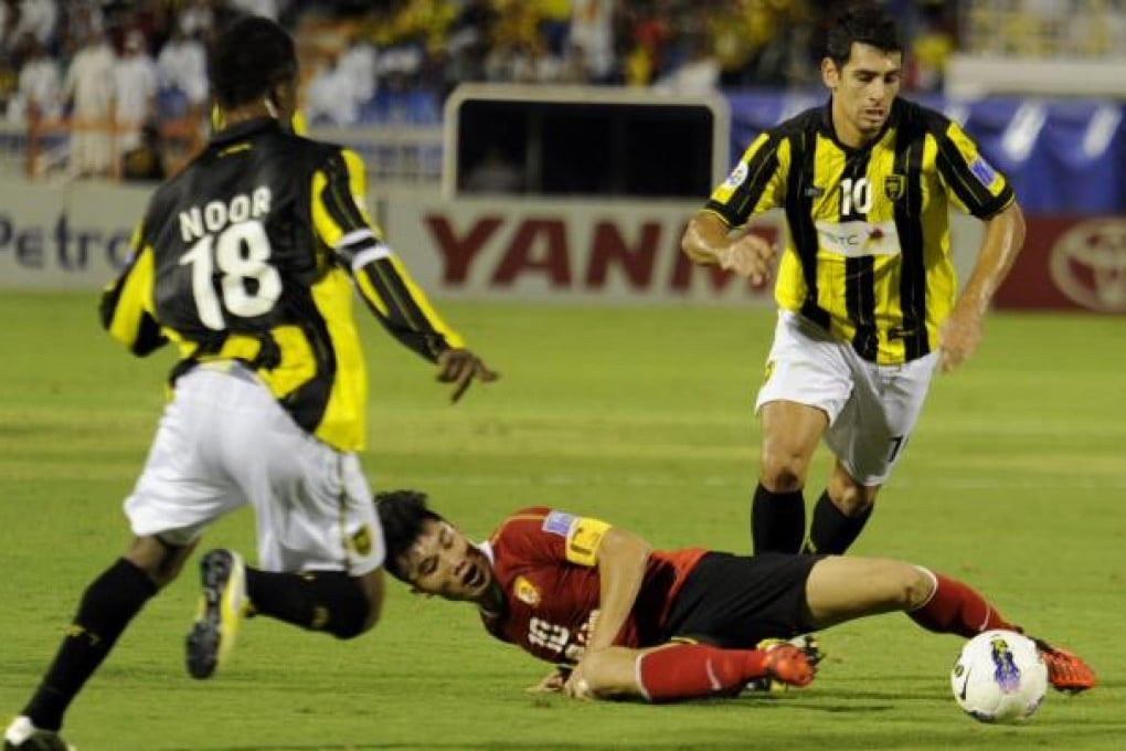 Guangzhou's Zhi Zheng battles with Mohammed Noor. Photo: AFP